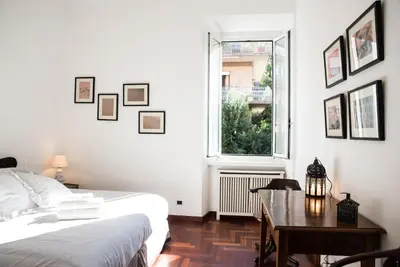 a bedroom with a bed and a table and a window at Porta Latina Apartment in Rome