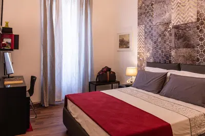 a bedroom with a large bed with a red blanket at Monticello apartment via Cavour in Rome