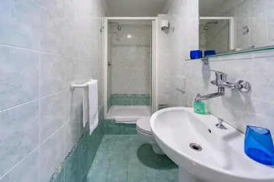 a white bathroom with a sink and a toilet at Monticello apartment via Cavour in Rome