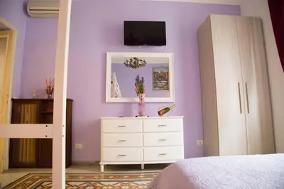 a bedroom with purple walls and a dresser with a mirror at Sweet Sleep Vatican in Rome