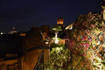 a city skyline at night with flowers on a balcony at Residenza Maritti Classic Rooms - Guesthouse in Rome