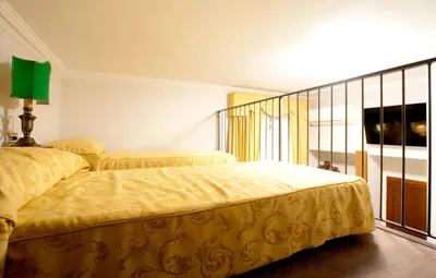 a bedroom with a yellow bed with a green lamp at Guesthouse Borromeo Roma in Rome