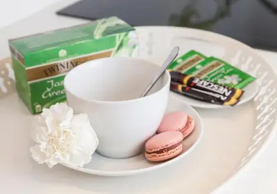 a white plate with a cup of coffee and cookies at Margherita Suites in Rome