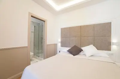 a bedroom with a large white bed and a window at Margherita Suites in Rome