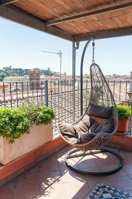 a wicker chair hanging on a balcony with a view at Il Nascondiglio del Prete in Rome