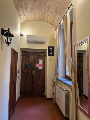 a hallway with a wooden door and a mirror at Navona Apartment Livia in Rome