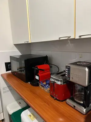 a kitchen shelf with a microwave and appliances on it at Navona Apartment Livia in Rome