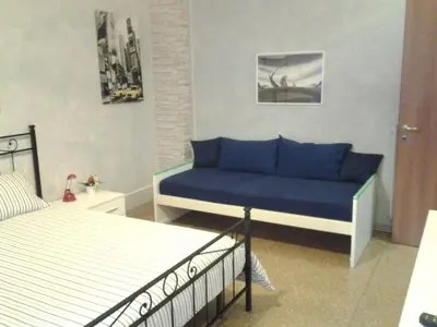 a living room with a blue couch and a bed at Long Bridge House in Rome