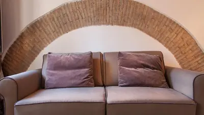 a brown couch with two pillows on it at Rental in Rome - Scala Suite in Rome