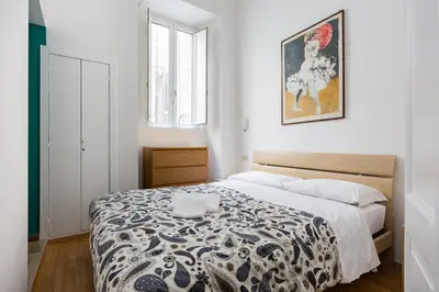 a bedroom with a bed with a black and white blanket at Casa Vacanze Colosseum by Alice in Rome