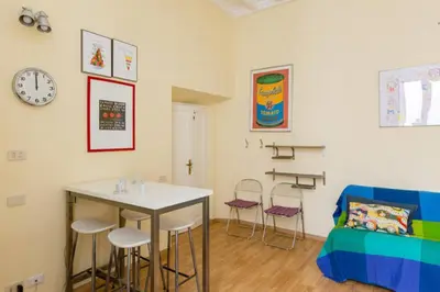 a living room with a table and chairs and a couch at Casa Vacanze Colosseum by Alice in Rome