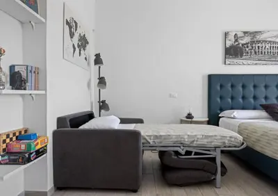 a bedroom with a bed and a table and a chair at Sapienza Apartment by RHR in Rome