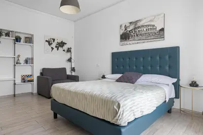 a bedroom with a blue bed and a chair at Sapienza Apartment by RHR in Rome