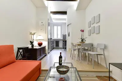 a living room with a red couch and a table at Campo de' Fiori Brand New Apartment in Rome