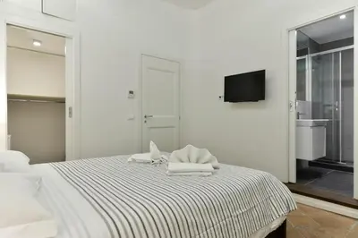 a white bedroom with a bed with towels on it at Campo de' Fiori Brand New Apartment in Rome