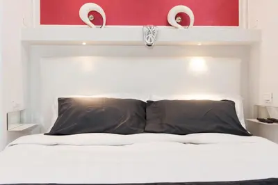 a bedroom with a white bed with a white headboard at Brunelleschi Holidays Hostel in Rome