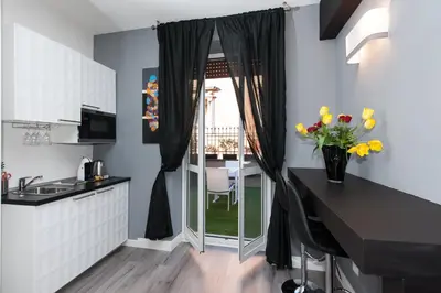 a kitchen with a window and a table with flowers at Brunelleschi Holidays Hostel in Rome