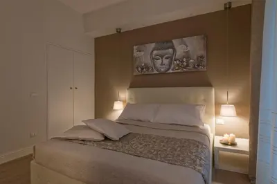 a bedroom with a bed with a painting on the wall at Aruna Suites in Rome