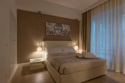 a bedroom with a bed with a portrait on the wall at Aruna Suites in Rome
