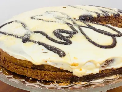 a chocolate cake with white frosting on a plate at BQ House Castello Luxury Rooms in Rome