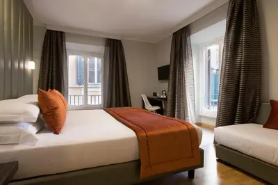 a hotel room with two beds and windows at Vittoriano Suite in Rome