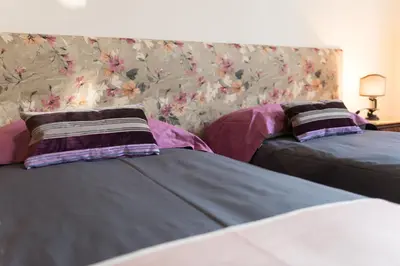a bedroom with two beds and a wall with flowers at Casa Minerva Al Pantheon in Rome