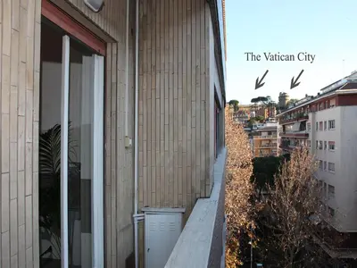 a building with a balcony with birds flying above it at Marina Home in Rome