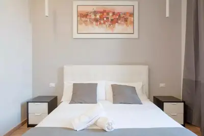 a bedroom with a white bed with two night stands at KayDee GuestHouse in Rome