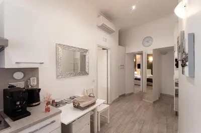 a white kitchen with a sink and a mirror at Central Vatican Rooms in Rome