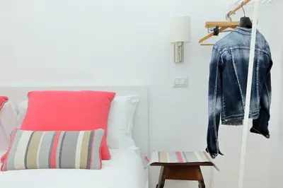 a leather jacket hanging on a wall next to a bed at YCH-Penthouse Fiammetta a Piazza Navona in Rome
