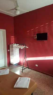 a room with a red wall with a tv on the wall at Art in Accommodation in Rome