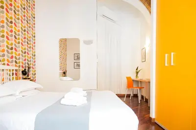 a bedroom with a white bed and a desk at TrastevereHome - Garibaldi Rome in Rome