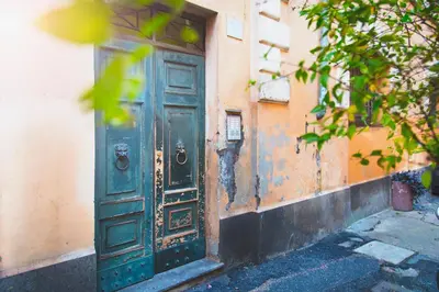 an old green door on the side of a building at TrastevereHome - Peretti Rome in Rome