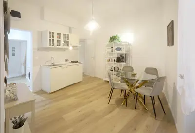 a kitchen and dining room with a glass table and chairs at Buongiorno Colosseo in Rome