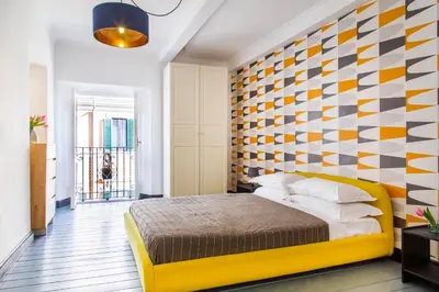 a bedroom with a yellow bed and a checkered wall at TrastevereHome - Ripa Rome Trastevere Home in Rome