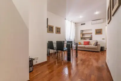 a living room with a table and chairs and a couch at Casa Zeffiro - FromHometoRome in Rome