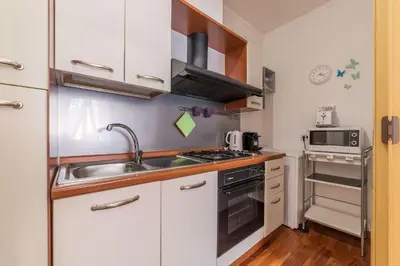 a small kitchen with a sink and a stove at Casa Zeffiro - FromHometoRome in Rome