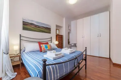 a bedroom with a bed in a room with white cabinets at Casa Zeffiro - FromHometoRome in Rome