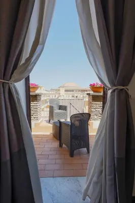 a patio with chairs and a table on a balcony at Arch Rome Suites in Rome