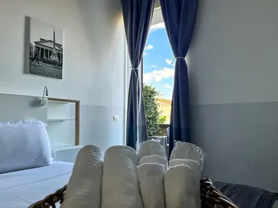 a bathroom with a toilet and a sink and a lamp at Arch Rome Suites in Rome