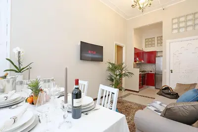 a dining room with a table with a bottle of wine at Liberty Rome Apartment - Liberty Collection in Rome