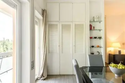 a dining room with a glass table and a window at Megi San Peter Apartment in Rome