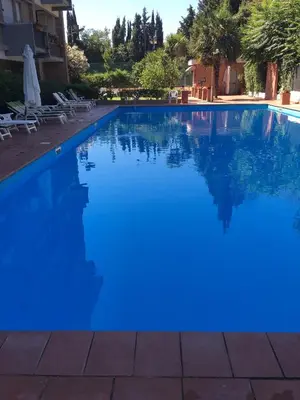 a swimming pool with blue water in a resort at Megi San Peter Apartment in Rome
