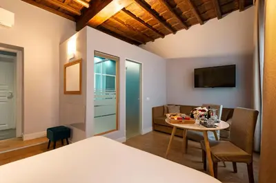 a room with a bed and a table and a couch at Le Suite del Barone in Rome