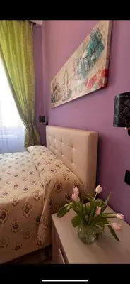 a bedroom with a bed and a vase with flowers on a table at Guest House Biondi in Rome