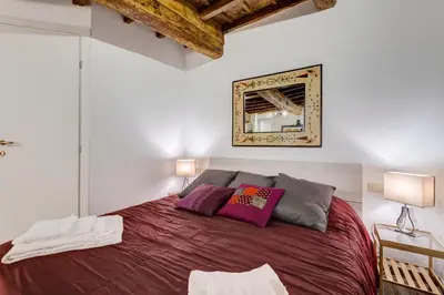 a bedroom with a large bed with purple pillows at Pellegrino Campo de' Fiori Suite in Rome