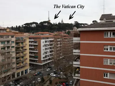 two birds flying over a city with buildings at Alice Home in Rome