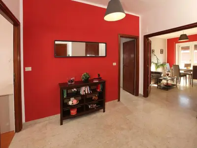 a living room with a red wall and a table at Alice Home in Rome