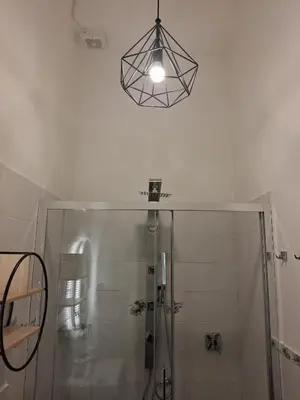 a bathroom with a shower and a chandelier at Double B Ferruccio I in Rome