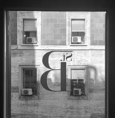 a sign on the side of a building with two windows at Saint B Boutique Hotel STB in Rome
